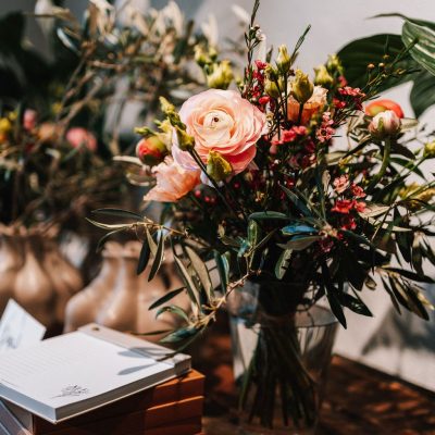 Eine hübsche Vase mit Blumen und einer Notiz auf einem Tisch, die eine einladende Stimmung erzeugt.
